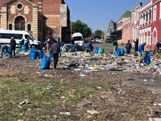 Volunteers remove the piles of rubbish which buried the public space along Market Street in Boksburg CBD on World Cleanup Day.