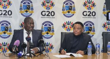 Ekurhuleni Mayor Doctor Xhakaza and Ekurhuleni city manager Kagiso Lerutla in the Mayor’s Parlour, with a white banner bearing the G20 and city of ekurhuleni logos in the background.