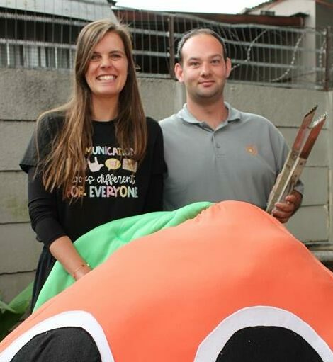 Woman with long dark hair with a man wearing a grey shirt.