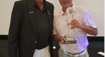 Ekurhuleni Golf Union president Jan Kruger in khaki pants and black top, with Kruger Jeremy Wright holding a trophy.