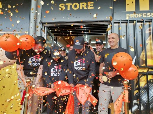 Four people cutting a ribbon to mark launch of a new store