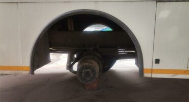 A white Ekurhuleni metro bus standing on bricks.