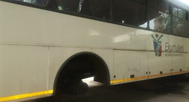 A white ekurhuleni municipal bus standing on bricks after it was stripped of its wheels by criminals