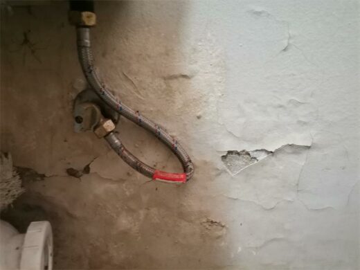 Cream white wall with cracks and blistering paint. Cream white wall with cracks and blistering paint.
