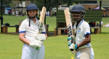 Two players in their cricket gear.