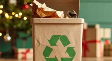 Recycling container standing in front of a Christmas tree