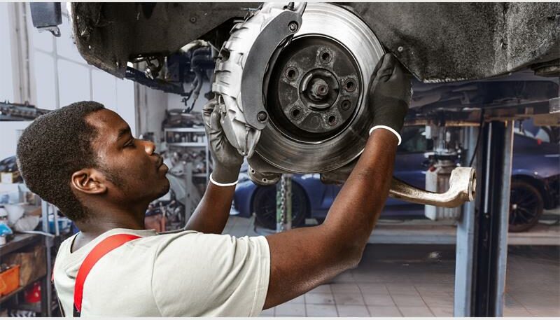 A man replacing brake discs and pads