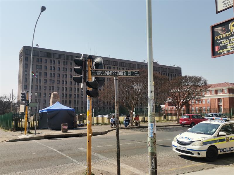 A building with multiple offices, traffic lights and a road.