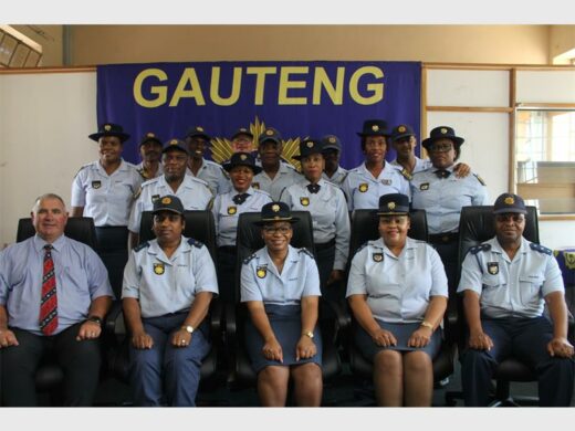 Police officers in uniform, with big SAPS banner