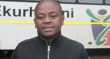 MMC for Roads and Transport Planning, Andile Mngwevu, standing in front of a metro bus.