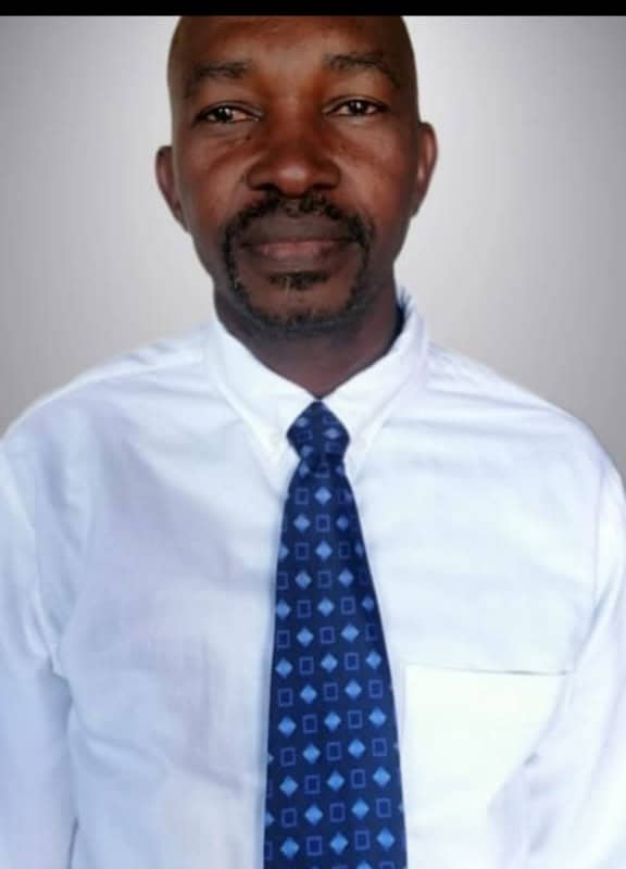 A Black man wearing a white shirt and a tie.