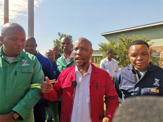A group of men in work suits standing outside municipal offices discussing about operations