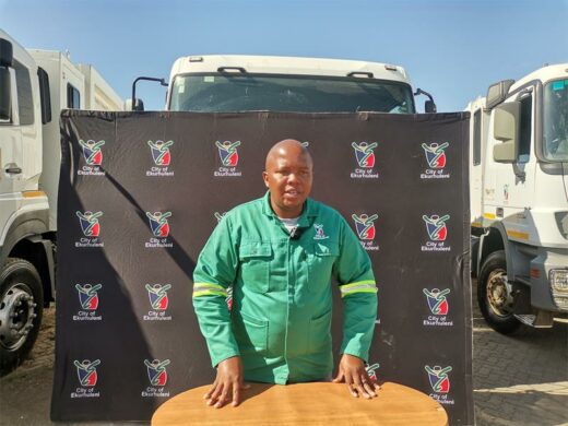A City of Ekurhuleni official in word suits with a truck in the background