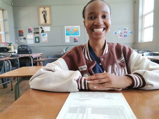 a young black woman wearing a pick and white jacket.
