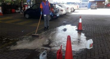 A staff member scrubs the forecourt of the Dalview petrol station