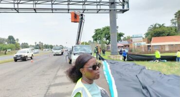 a woman standing next to an billboard
