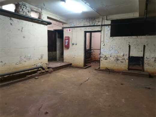 building basement in disrepair, with crumbling surfaces and damaged walls