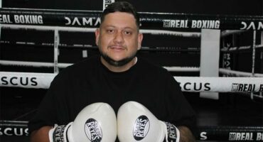 Man dressed in black t-shirt with boxing gloves.