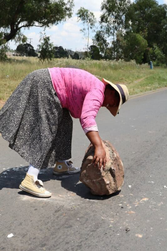a woman rolling a rock onto the road