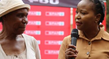 two black women, one of them holding a microphone