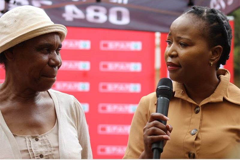 two black women, one of them holding a microphone
