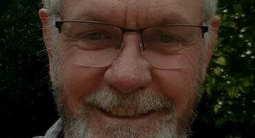 a profile photo of a man with gray hair