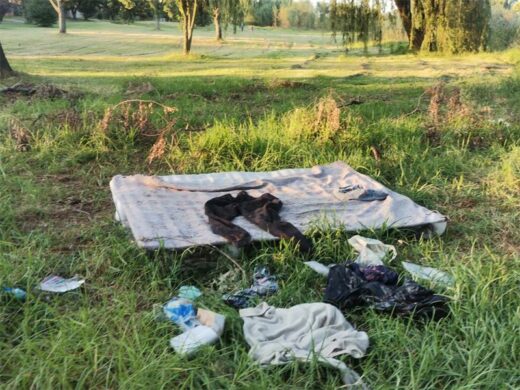 Belongings, including blankets, clothes, and a mattress