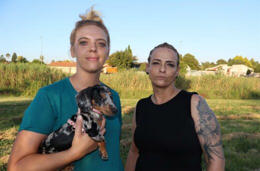 two women standing in a park