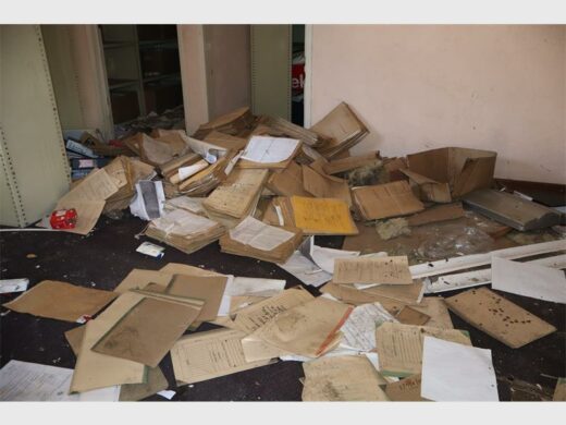 Piles of case dockets and other official documents lie scattered across the floor of a vandalised facility.