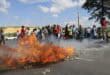 protesters blockade road with rocks and burning objects