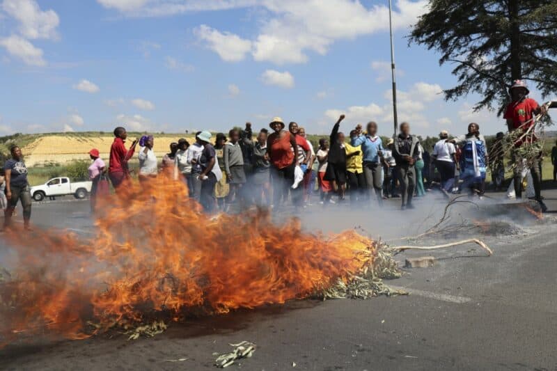 protesters blockade road with rocks and burning objects