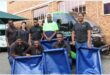 A group of workers from a factory standing in front of a vehicle with dog beds they have donated to the SPCA.