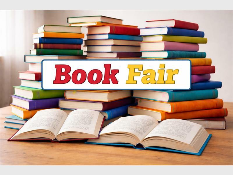 Books stacked on a table with the wording Book Fair.