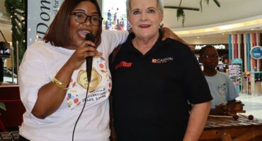 Two women one wearing a white top and the other in a black Boksburg Advertiser branded golf t-shirt