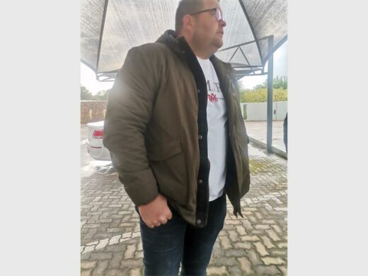 a man standing under a carport