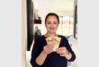 A woman in a black top holding R40 in cash