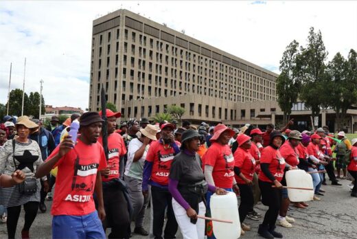 A group of protesting women and men with the vast majority of then wearing red t-shirts