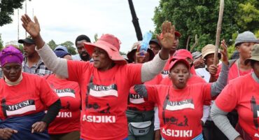 A group of protesting women and men with the vast majority of then wearing red t-shirts