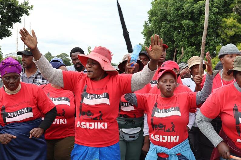 A group of protesting women and men with the vast majority of then wearing red t-shirts