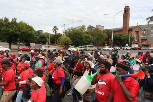 A group of protesting women and men with the vast majority of then wearing red t-shirts