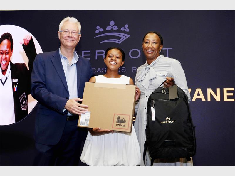 A white man on the left with two black females, one a student holding a package, all smiling with joy.