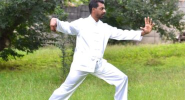 An Indian man dressed in white outfit