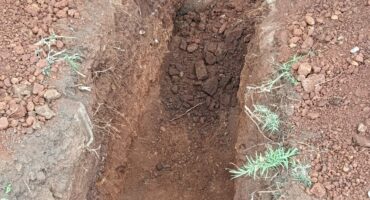 A man digging to access a damaged underground cable