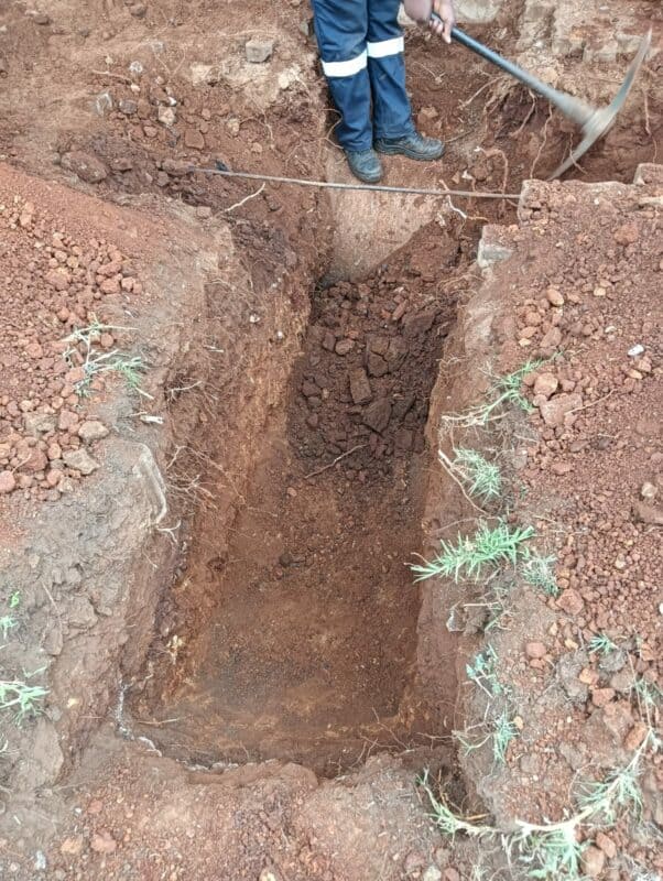A man digging to access a damaged underground cable