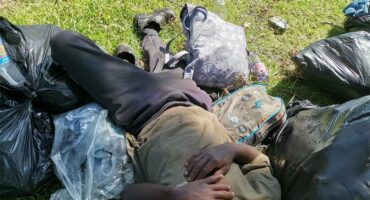 a man sleeping on the grass in a park