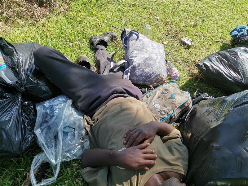 a man sleeping on the grass in a park