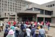 A group of protesting women and men with the vast majority of then wearing red t-shirts