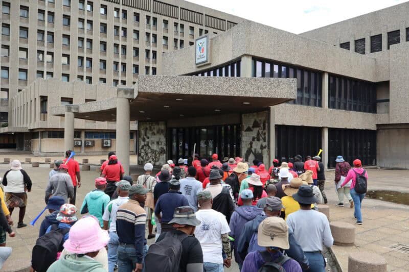 A group of protesting women and men with the vast majority of then wearing red t-shirts