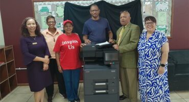 A group of people standing beside a printer