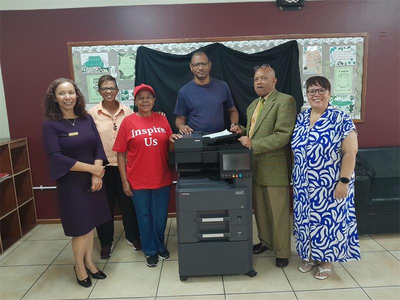 A group of people standing beside a printer